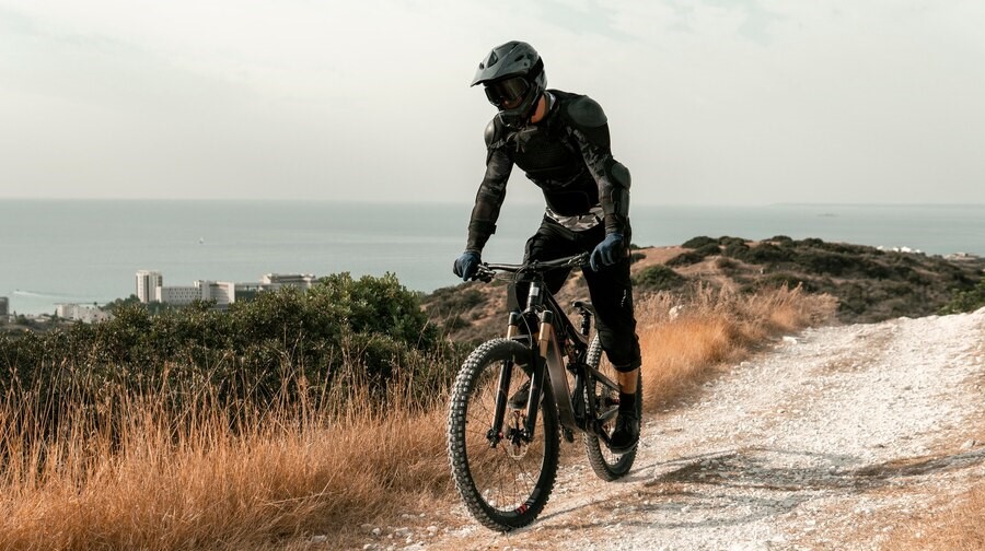 Contact banner. Man riding bike with backdrop of city and the ocean